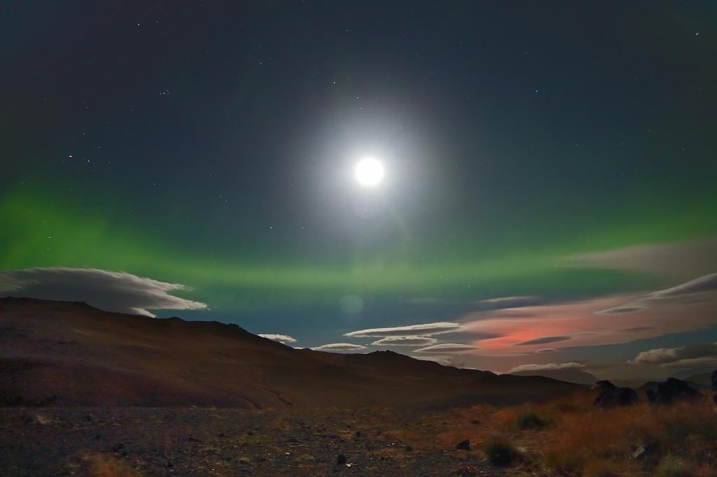D700_12033JMcf.jpg - Grünes Polarlichtband über den vom Vulkanausbruch des Bardarbunga rot angestrahlten Wolken. Darüber der helle Vollmond.